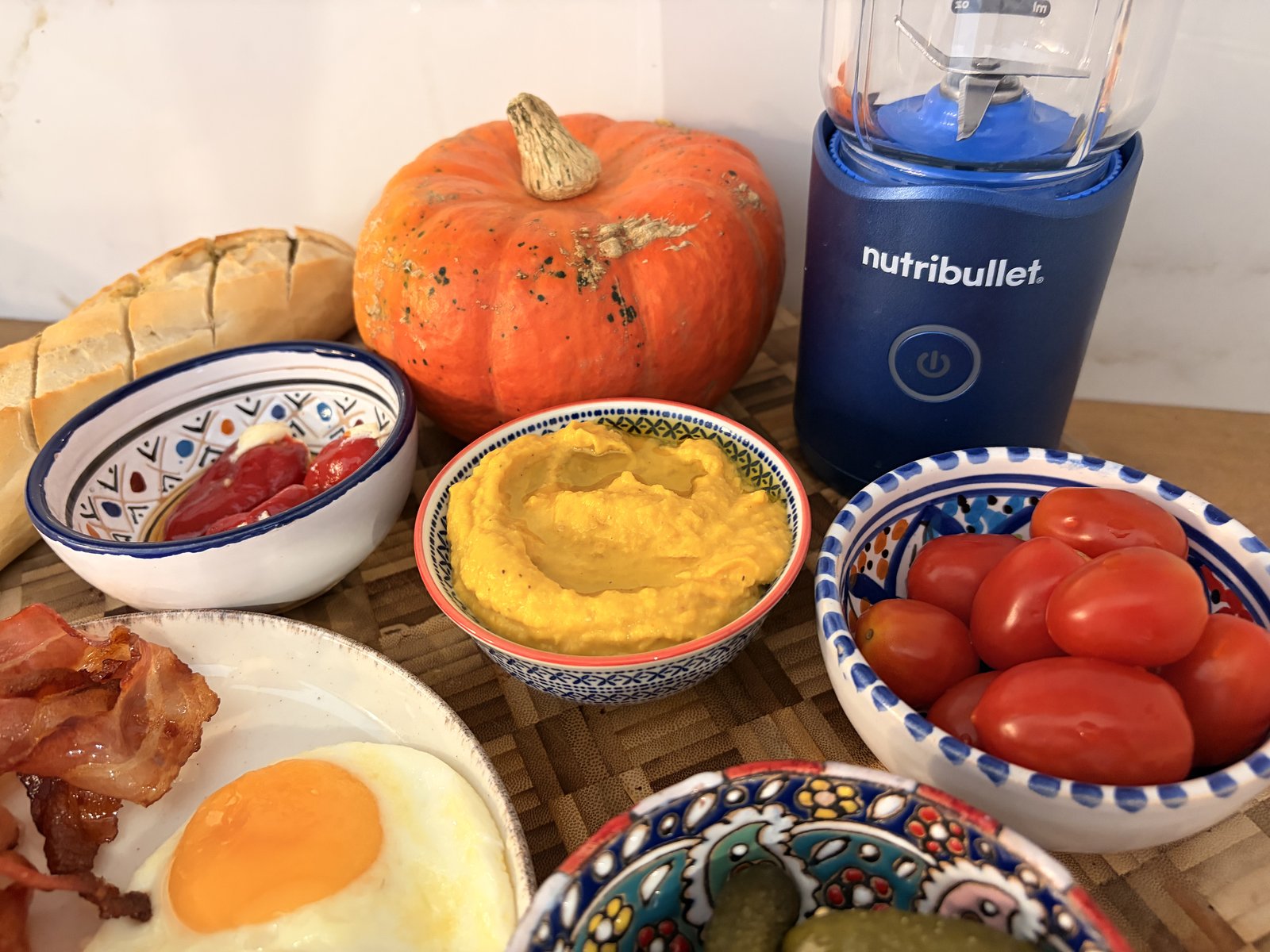 dyniowy hummus w miseczce obok blendera nutribullet flex i dyni hokkaido