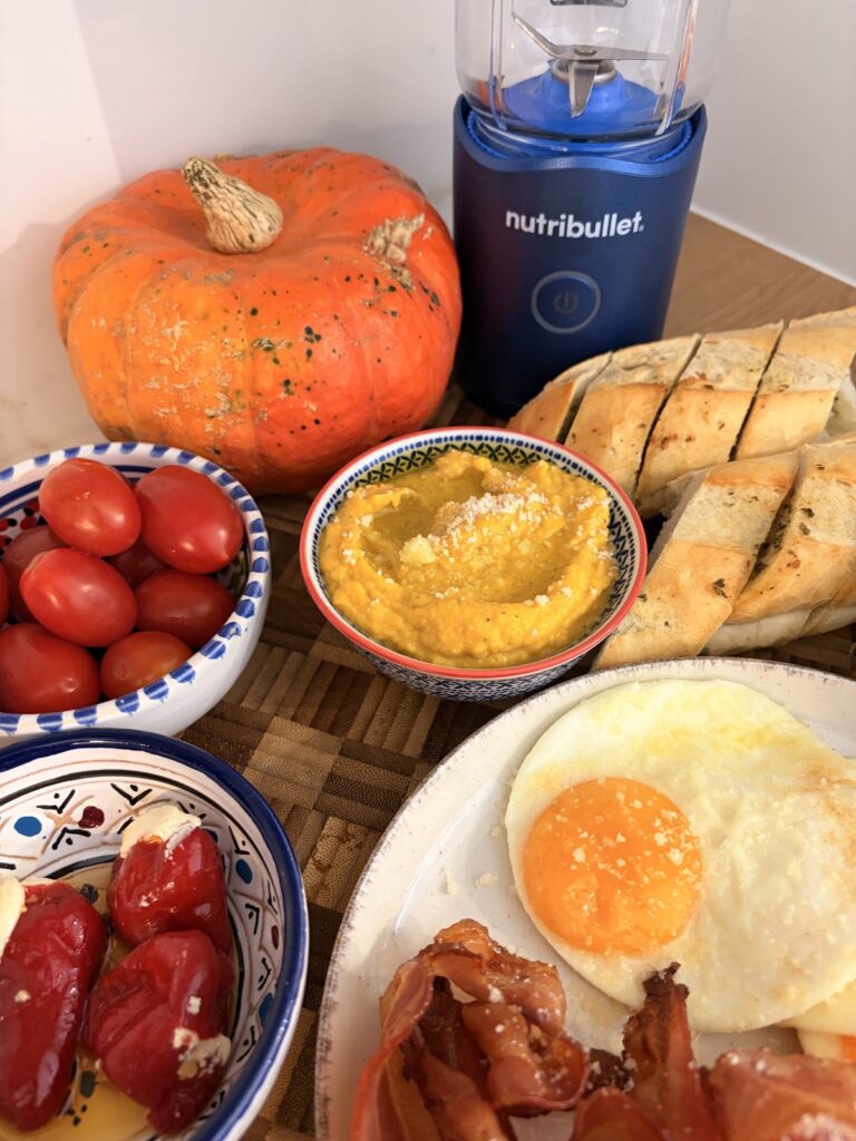 gotowy dyniowy hummus w ceramicznej miseczce z pieczywem czosnkowym